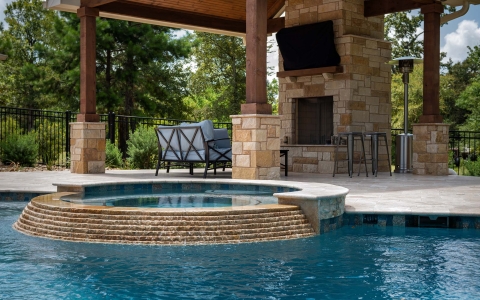outdoor fireplace in front of swimming pool